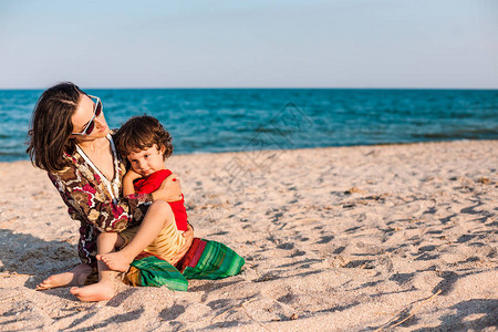 孩子和妈在海滩上男孩正在和他的妈玩耍孩子妈并微笑一个女人和她的儿图片