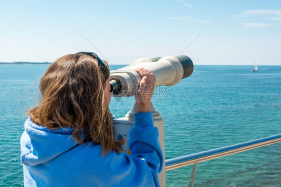 女人在海边看硬币操作的双筒望远镜旅游图片