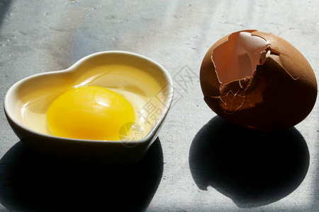 带破壳的棕色鸡蛋和灰色背景的搅拌器背景图片