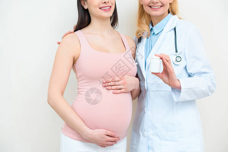 产科妇产科医生和孕妇服用一罐药丸的图片