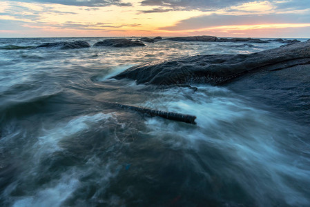 黄昏时的长曝光海景岩石图片