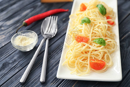 餐桌上有意大利面和西红柿美味的图片