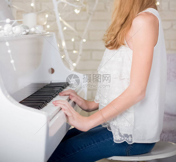 弹奏白色三角钢琴的女孩图片