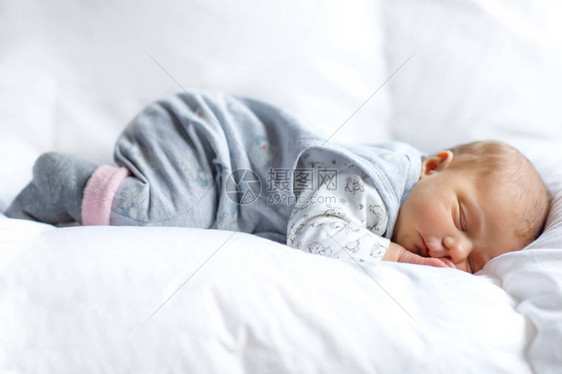 可爱的和平新生婴儿睡在白色的床上图片
