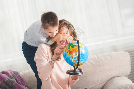 母亲和儿子在家中玩耍与地球一起图片