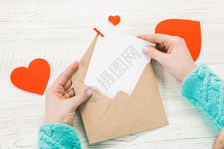 在圣情人节写情书的女孩之手与红色心形图的手工制作的明信片2月14日节庆典带有复制空间图片