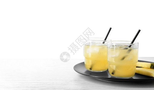 白桌上放着菠萝片和一杯新鲜果汁的盘子图片