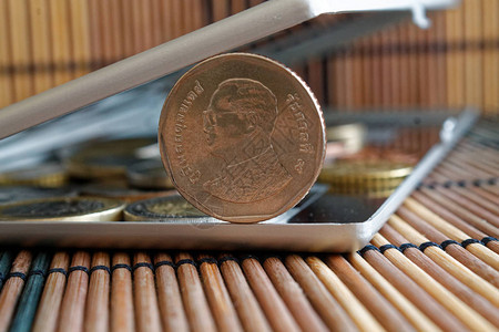 镜面反射钱包中的一堆泰国硬币位于木竹桌背景上面额为5图片