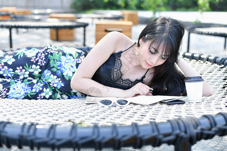 教育理念亚洲妇女在公园里读书美丽的女人在公园里放松美丽的女图片