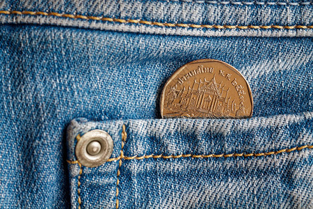 泰国硬币在轻蓝牛仔裤口袋中面额为5图片
