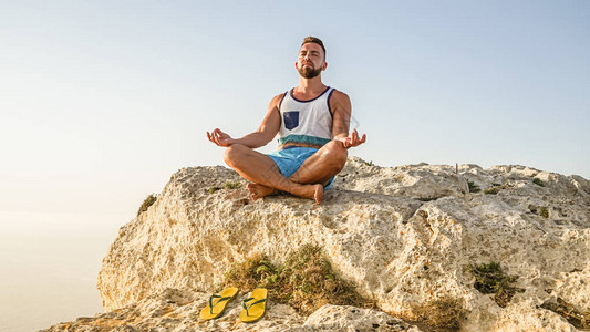 "佛系"近距离近距离的胡须成年男子肖像制作莲花姿势和在海面背背景