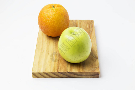 白色背景上木板上的橙色和苹果图片