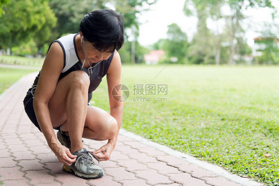 资深女子慢跑者收紧她的跑鞋带图片