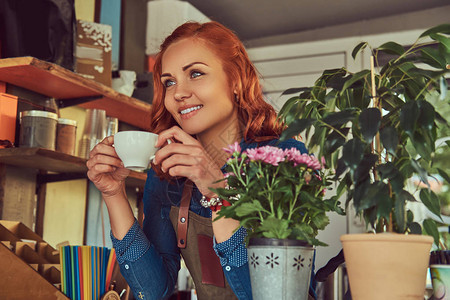 美女红发女咖啡师在咖啡店喝咖啡图片