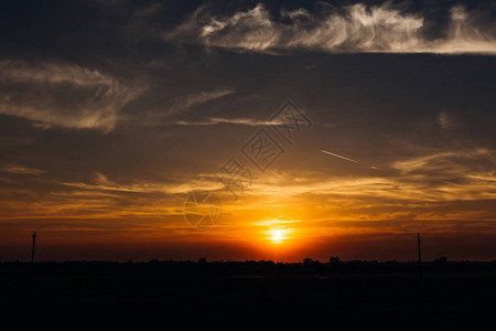 日落橙色天空云朵和飞机线图片