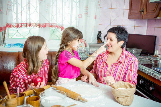 妈在厨房教她的两个孩子做饭父母与制作最小的女儿和一个患有唐氏综合症的17岁女儿一起制作馅饼和干家庭在家里的图片