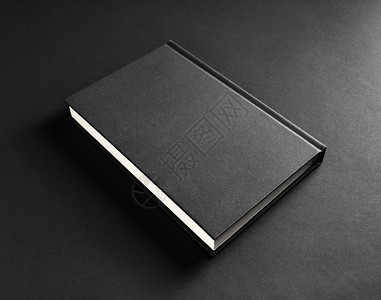 黑纸背景上的空白黑书封面照片图片