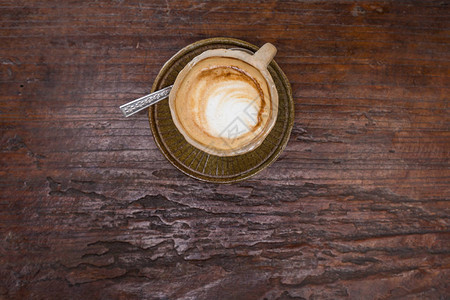 木桌上石杯中的拿铁艺术热咖啡香气饮用图片