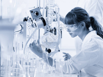 化学实验室研究有吸引力的年轻女博士研究生在溶液蒸馏后观察蓝色指图片