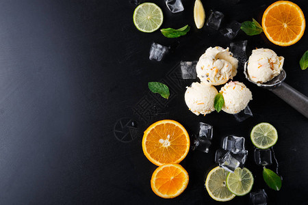 冰淇淋夹冰块柠檬和橙片薄荷和黑底勺美味的冷甜点顶视图片