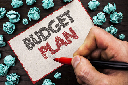 显示预算计划的文本符号概念照片会计策略预算财务收入经济学由持有标记纸板的人在木背景图片
