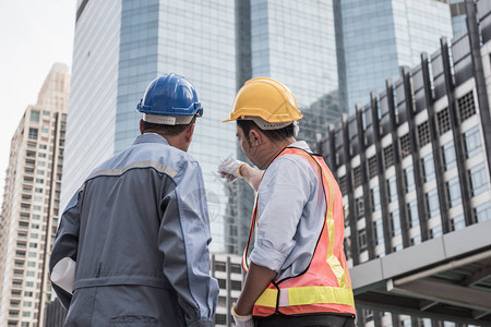 建筑师和土木工程师在建筑工地一起工作的背影图片