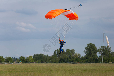 与橙兰花降落伞对抗蓝天的伞兵背景图片
