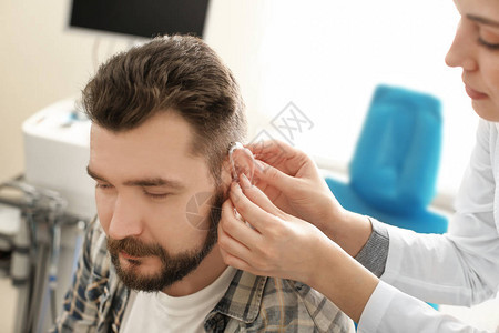 耳鼻喉科医生在医院将助听器放在人的耳朵里图片