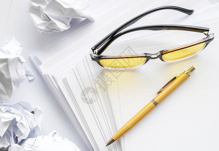 一张白纸上的黄色钢笔和黄色眼镜写着图片