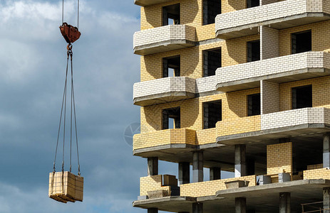 起重机为建造一座房屋提供建筑材料蓝图片