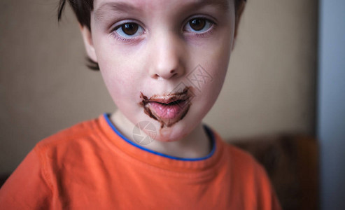 男孩用勺子吃饭婴儿被食物弄脏了一个脸很脏的孩子一图片