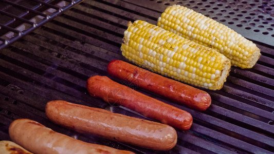 夏天在户外燃气烧烤炉上烹制热狗和小香肠图片