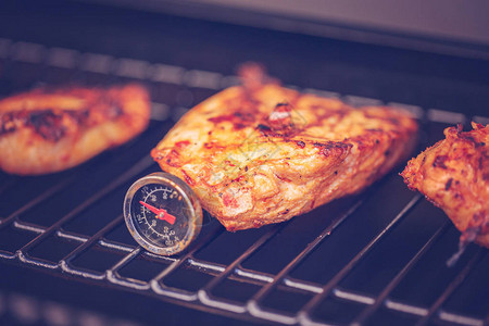 在户外的燃气烤架上烹制辣鸡胸肉图片