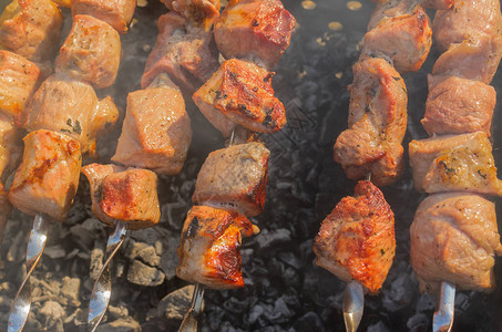 多汁的猪肉在阴燃的碳上户外烹制图片