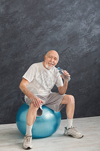 穿着运动服的口渴老人在训练后放松图片