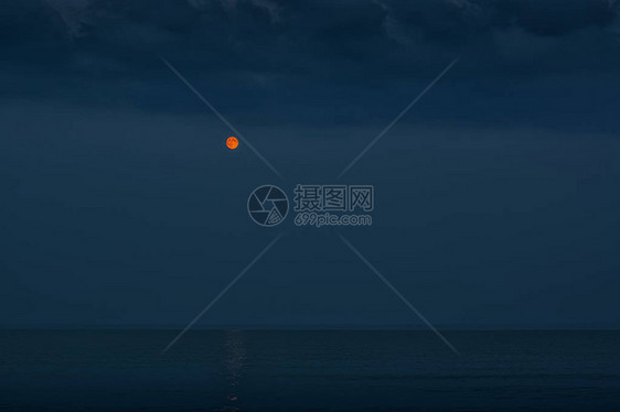 海景黑夜映衬下的红月图片