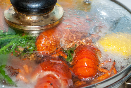 新鲜的红龙虾在沸水锅中煮熟图片