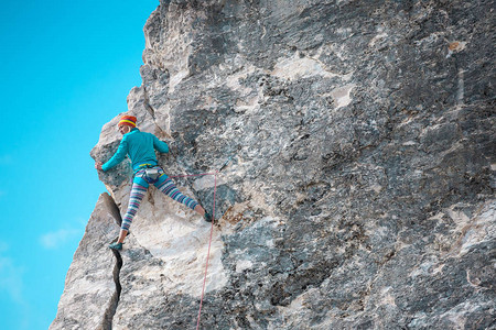 岩石上的攀岩者女人在美丽的天空与云彩的背景下爬上岩石积极的生活方式自然运动克服困图片