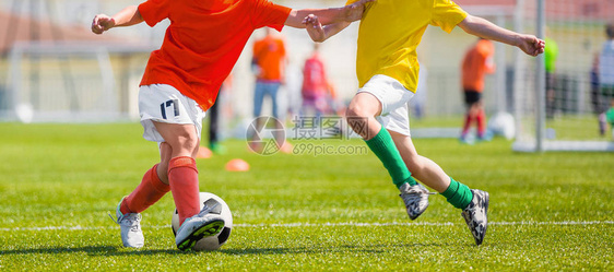 一群小男孩在运动场上踢足球比赛足球学校比赛黄色和红色球衣衬衫的儿图片
