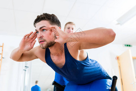 运动员及其理疗师在健身俱乐部健身房运动设备锻炼背景图片