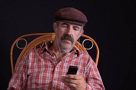 坐在摇篮椅上用耳机监听音乐的乌克兰乡图片