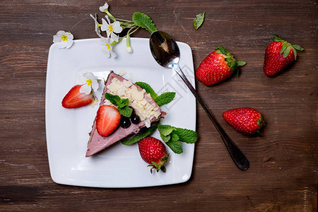黑盘上的草莓芝士蛋糕在生锈图片