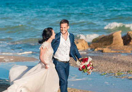 新娘和新郎在海边的海滩上举行婚礼微笑的新娘和新郎恋爱图片