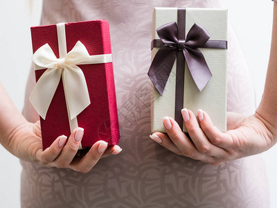 节日礼物惊喜女人在她背后拿着两个礼品盒图片