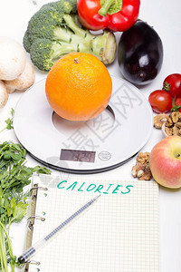 将产品蔬菜厨房电子尺度的水果和书写价值与卡路里计数清单相比图片
