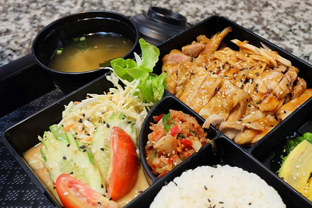 传统日本料理便当盒或多层盒配照烧鸡肉饭沙拉玉子烧或煎蛋卷HiyashiWakame或海藻沙拉和图片