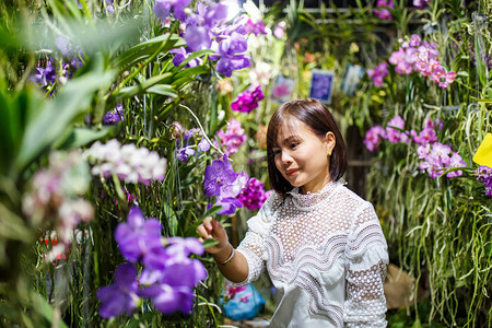 微笑着年轻的年青的年轻女在花图片