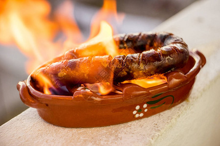 在酒精特制粘土锅中制作的传统的葡萄牙语或西班牙chourico或ch图片