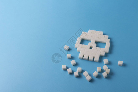 蓝色背景上的糖块和糖块的头骨概念糖对人体图片