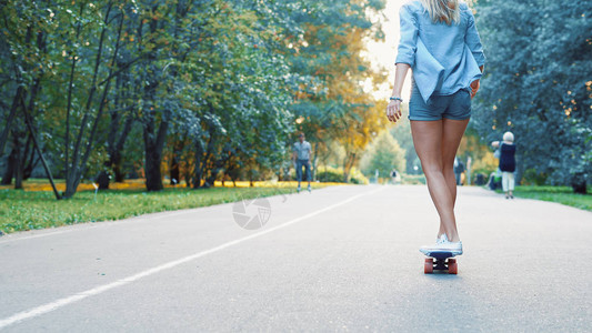 在夏季公园滑冰的年轻女孩图片